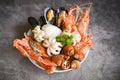 Seafood shrimps prawns squid mussels spotted babylon shellfish crab  on plate and dark background - Cooked food served seafood Royalty Free Stock Photo