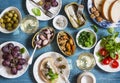 Seafood snacks table - canned sardines, mussels, octopus, grape, olives, tomato and two glasses white wine on wooden table, top vi