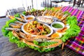 Seafood Somtum has clams, shrimp, crabs, boiled eggs, grilled tilapia, placed in a beautifully placed tray on wooden table