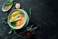 Seafood soup. Creamy tuna soup in a bowl on a black stone background. Top view. Rustic style Royalty Free Stock Photo