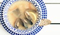 Seafood soup with mussels, prawns and fish in white bowl with blue ornament on the wooden table in restaurant, top view Royalty Free Stock Photo