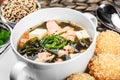 Seafood Soup with salmon, cheese, seaweed, sesame and bread on plate on wooden background.