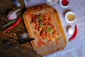 On a dark countertop, a light linen napkin, on a cutting board Seafood Squid in batter with sauce and spices on a board on a dark Royalty Free Stock Photo