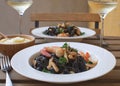 Seafood Squid ink pasta closeup Shrimp White wine Alioli Restaurant terrace Wooden table Royalty Free Stock Photo