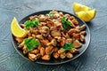 Seafood. Steamed Musseles appetizer with sprinkle of parsley and lemon juce served on black plate. Royalty Free Stock Photo