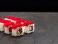 Seafood sushi roll with tuna inside and red flying fish roe Tobiko caviar on top served on concrete background