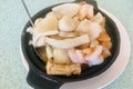 Seafood tofu stew in casserole. green table background.