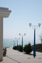 Seafront, boulevard by the sea with lanterns and thuja