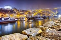 Seafront of Douro River in Porto in Portugal At Dusk with Line of Moored Wooden Boats. Dom Luis I Bridge on The Background