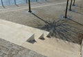 Seafront with plane trees growing out of the lattice in the pavement. a beige concrete staircase serves as a theater bench overloo