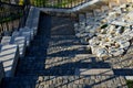 Seafront with plane trees growing out of the lattice in the pavement. a beige concrete staircase serves as a theater bench overloo