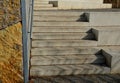 Seafront with plane trees growing out of the lattice in the pavement. a beige concrete staircase serves as a theater bench overloo