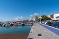 Seafront promenade with boats moored port of L`Ampolla, Catalonia, Tarragona Province Spain