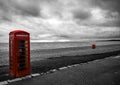 Seafront scene mostly black and white with red telephone box and lifebuoy, Dramatic sky\'s overhead