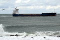 Seagoing vessels sailing past cause waves on the quays