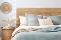 Seagrass wicker headboard in a coastal bedroom in soft blues and neutrals