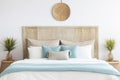 Seagrass wicker headboard in a coastal bedroom in soft blues and neutrals