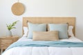 Seagrass wicker headboard in a coastal bedroom in soft blues and neutrals