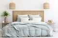 Seagrass wicker headboard in a coastal bedroom in soft blues and neutrals