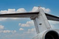 A seagull sits on the wing of an airplane against the backdrop of a blue cloudy sky