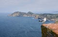 Seagull with the coast in the background surrounded by sea Royalty Free Stock Photo