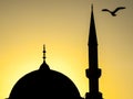 A seagull over the dome and minarette of a mosque at sunset Royalty Free Stock Photo