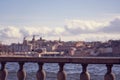 Seagull portrait in city. Close up view of a bird sitting on a sea shore against a blue water and blurred old city of Stockholm Royalty Free Stock Photo