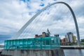 A seagulls flies at a low altitude near the Gateshead Millennium Bridge at Newcastle Quayside. The Baltic Centre for Contemporary Royalty Free Stock Photo