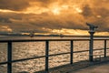 Seagulls on metal railing at sunset