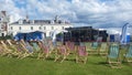 Empty deck chairs with fabric blowing in the wind in front of Cookery Theatre Stage on a green at a festival