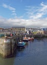 Seahouses  Harbour at Low Tide, with Boats resting on the silty bottom of the Harbour, overlooked by Houses Royalty Free Stock Photo