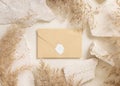 Sealed envelope near beige travertine stones and dried pampas grass top view, greeting mockup Royalty Free Stock Photo