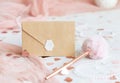 Sealed envelope near pink decorations, hearts and tulle on white table close up, mockup