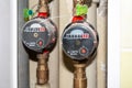 Sealed hot and cold water meters placed in a recess in the bathroom wall on the pipes. On the hot water meter, the value is zero Royalty Free Stock Photo