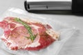 Sealer for vacuum packing with plastic bag of meat on light grey table, closeup Royalty Free Stock Photo