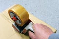 Sealing cardboard box with tape dispenser Royalty Free Stock Photo