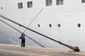 A seaman - seafarer with safety clothes washing the windows of a cruise ship docked at the Port of Corfu