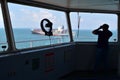 Seaman on the watch, looking at the container vessel passing