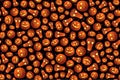 Seamless background for Halloween, different pumpkins with luminous faces on a dark background