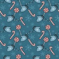 Seamless Christmas and Happy New Year pattern with lollipops, candy canes, snowflakes and mittens on blue background