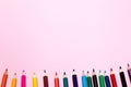 Seamless colored rainbow pencils row with wave on lower side, several arrangements, on pink paper. Concept of free space, Royalty Free Stock Photo