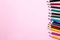 Seamless colored rainbow pencils row with wave on lower side, several arrangements, on pink paper. Concept of free space, Royalty Free Stock Photo