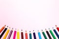 Seamless colored rainbow pencils row with wave on lower side, several arrangements, on pink paper. Concept of free space, Royalty Free Stock Photo