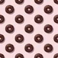 Seamless diagonal pattern with glazed chocolate donuts and pastel pink background. Confectionery banner