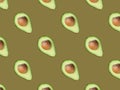 Seamless diagonal pattern of halved ripe avocados with pit on beige greenish background. Creative food backdrop for cooking oil