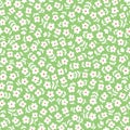 Seamless ditsy floral pattern in vector. Small white flowers on a green background