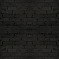 Seamless image of an old wall made of black, worn brick. Dark seamless background. Brick texture with symmetrical patterns Royalty Free Stock Photo