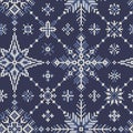 Seamless knitted pattern from white-blue snowflakes