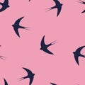 Seamless pattern with blue swallow birds on a pink background