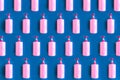 Seamless pattern of bottles with pink dishwashing liquid and sponges on blue background. Royalty Free Stock Photo